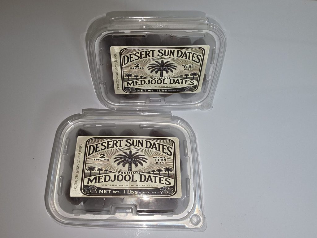 Two sealed containers of Desert Sun Dates California dates with farm labels facing forward